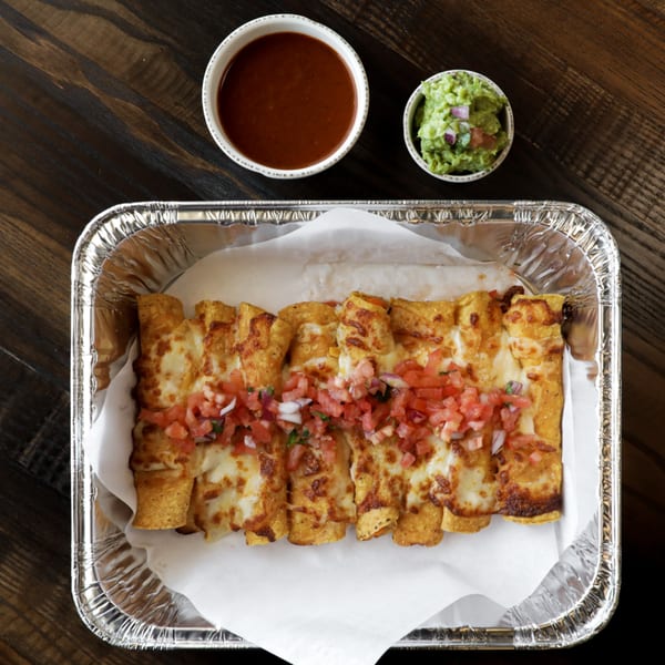 Cheesy enchiladas topped with pico de gallo, served with sides of salsa and guacamole.